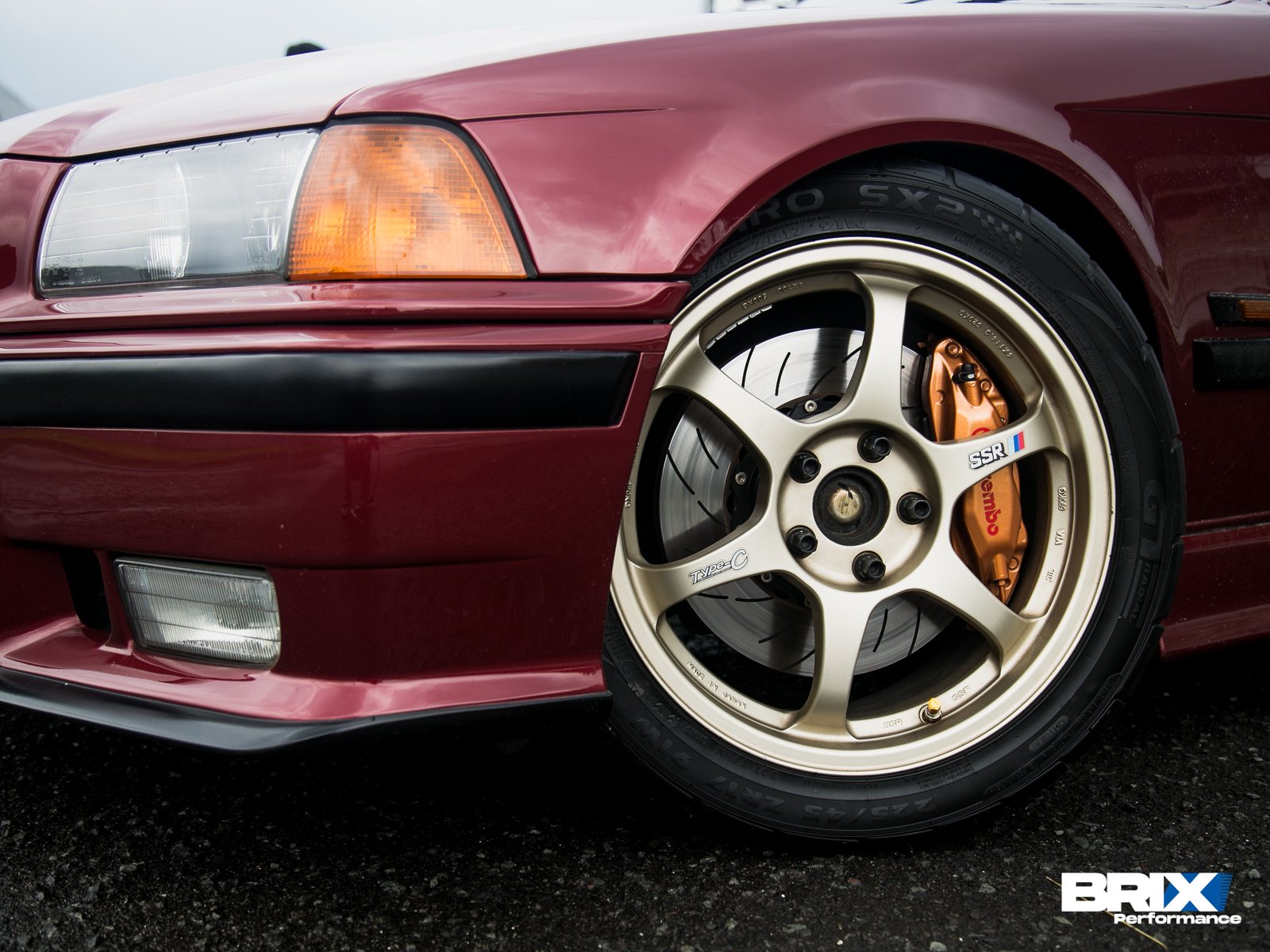 Close-up of BMW E36 front wheel with BRIX Performance Competition Series rotor and Brembo caliper.