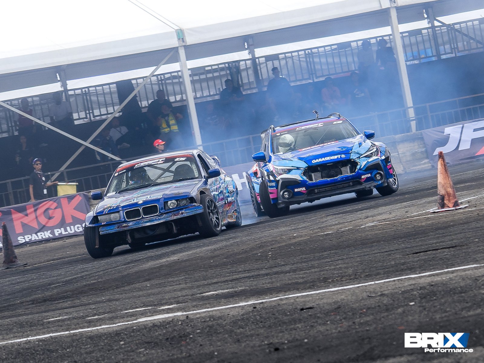 Subaru Crosstrek and BMW drifting side-by-side through a clipping point at Southeast Asia Drift Series.