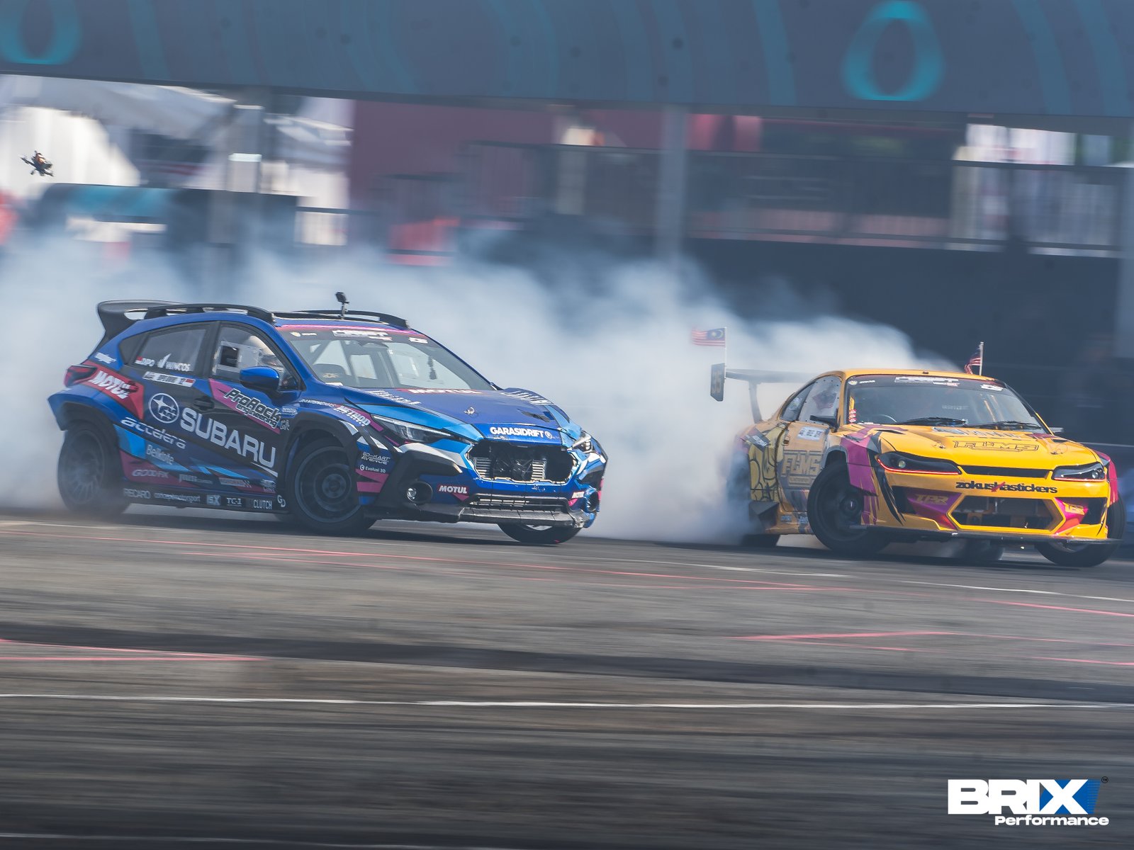 Subaru Crosstrek and yellow S15 Silvia in close tandem run with tire smoke trailing both cars.